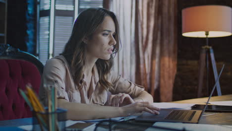 focused business woman working on laptop at evening. business specialist