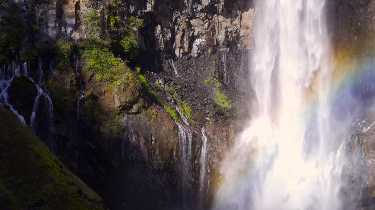 increíble vista de la cascada con el arco iris cayendo por acantilados verdes