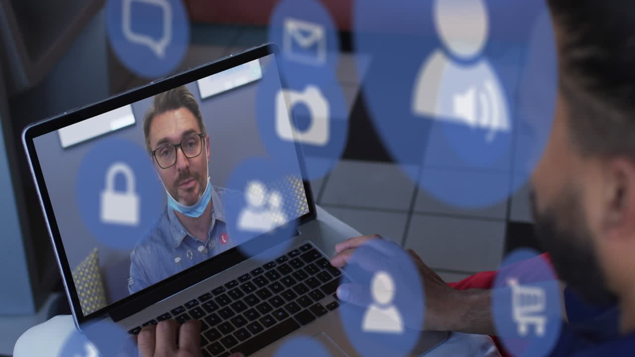 animación de iconos de los medios sobre un hombre caucásico con máscara facial haciendo una videollamada con una computadora portátil