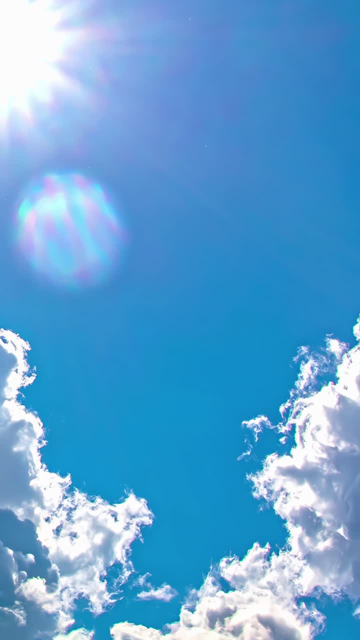 Thick white clouds swirling in a blue sky during a time lapse shot