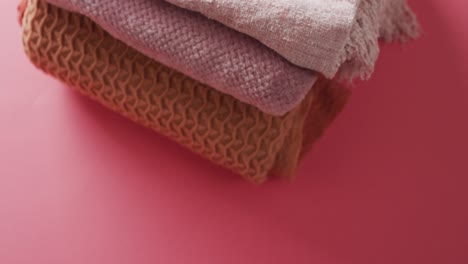 Video-of-folded-blankets-lying-on-pink-background