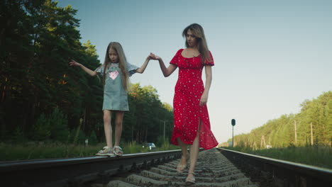 young boy in casual outfit walking alone on rail track surrounded by overgrown rural landscape, viewed from behind with converging railway lines creating deep perspective