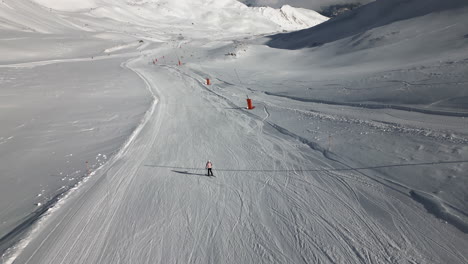 aerial follow of female skiing down ski hill in serfaus austria