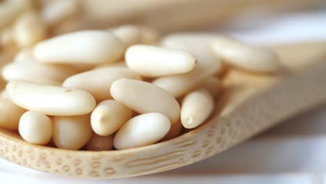 pine nuts in wooden spoons