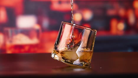 whisky siendo vertido en un vaso con hielo