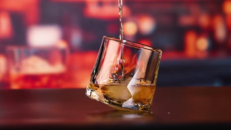 whiskey being poured into a glass with ice