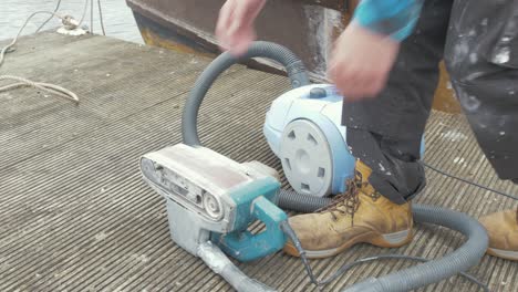 turning on a vacuum connected to a belt sander