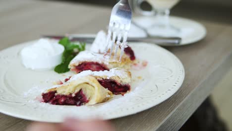 unrecognizable man in white t-shirt taking desert strudel at the restaurant using fork and knife. slow motion shot