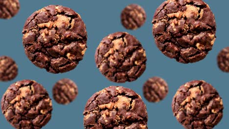 una corriente de galletas de chispas de chocolate de colección de diferentes diámetros en el fondo azul de tendencia (horizontal, no loopable) en imágenes de 4k uhd
