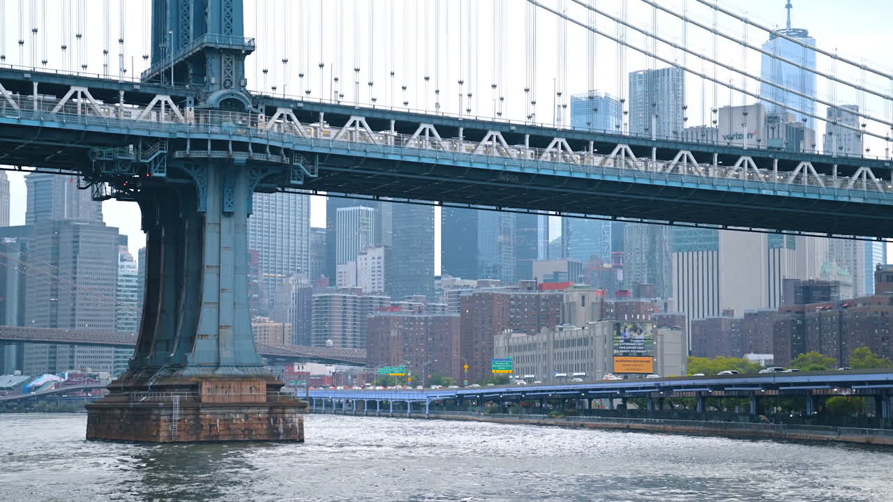 Imponente pilastro del Manhattan Bridge sull'acqua. Una vista ravvicinata della torre del Manhattan Bridge che si erge sull'East River a New York.