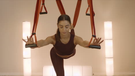 Mujer-Practicando-Yoga-Con-Correas-En-El-Estudio.-Dama-Seria-Entrenando-En-El-Interior