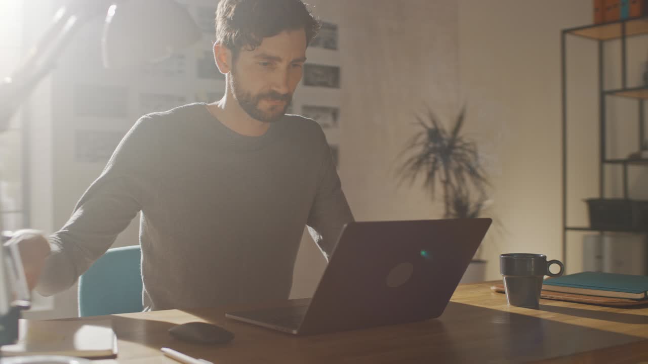hombre creativo profesional sentado en su escritorio en el estudio de la oficina en casa trabajando en una computadora portátil, hombre concentrado usando una computadora de portátil. movimiento enérgico de ritmo rápido. tiro de arco de seguimiento de 360 grados