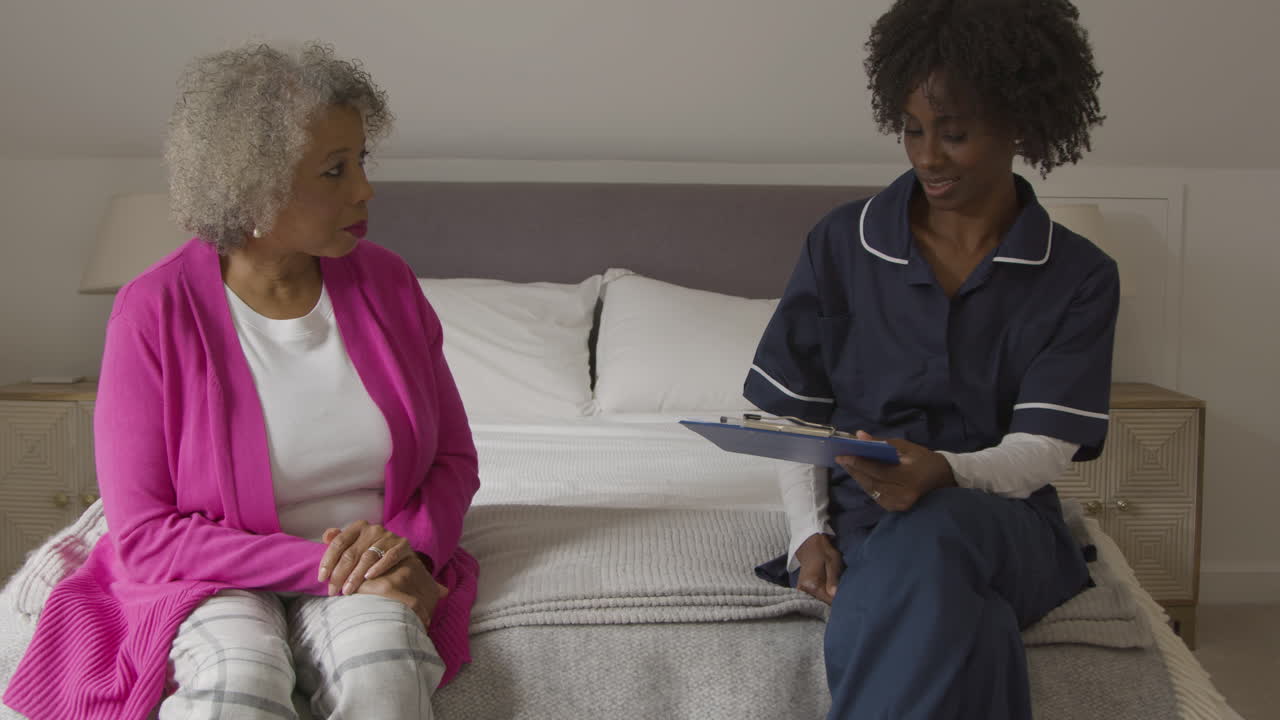 enfermeira de meia-idade realizando visita domiciliar com mulher sênior