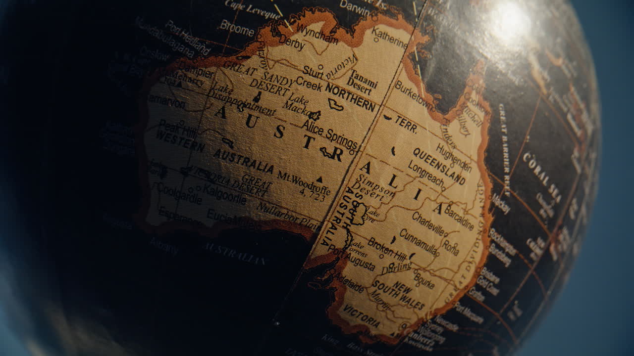 Australia continent placed globe closeup. Yellow mainland surrounded dark oceans