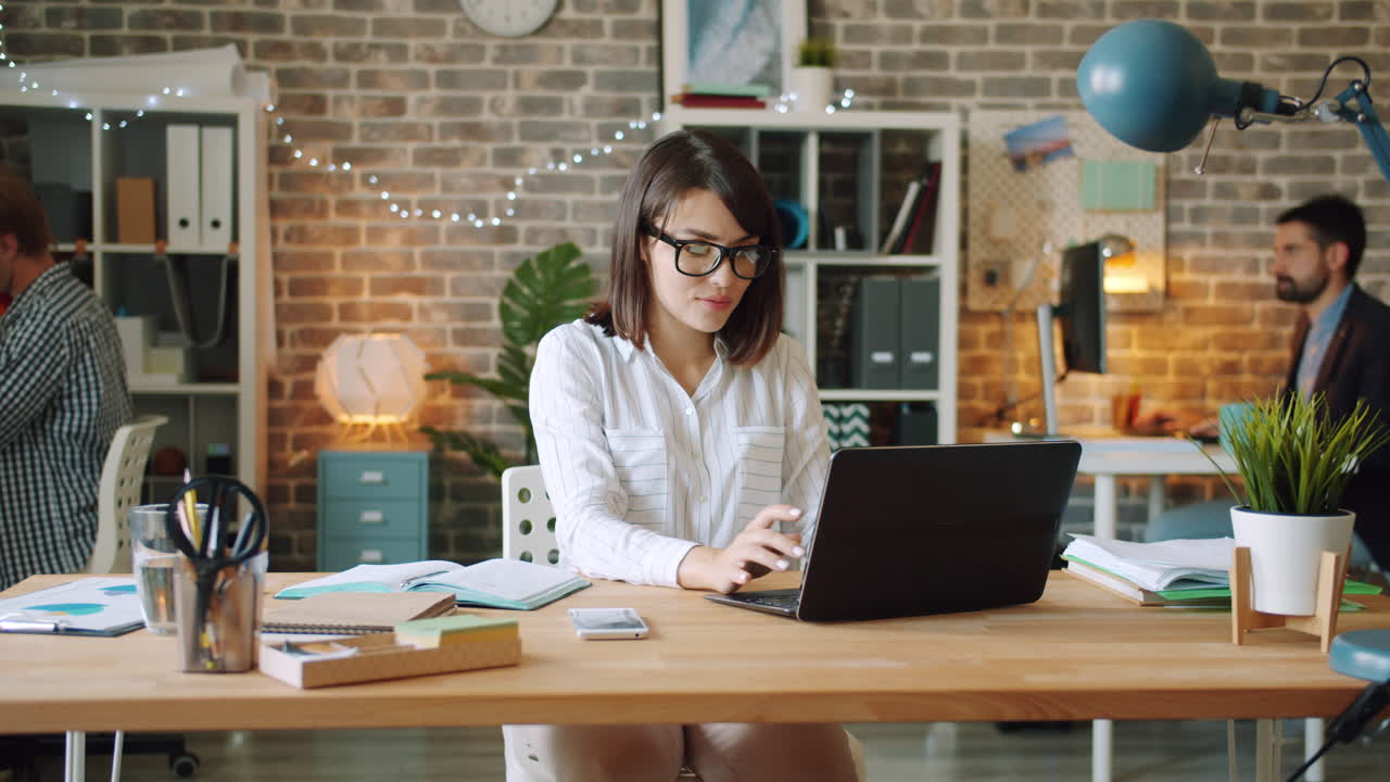 mujer trabajando en una computadora portátil en una oficina moderna