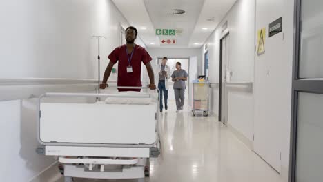 focused african american male nurse walking with hospital bed in slow motion, unaltered