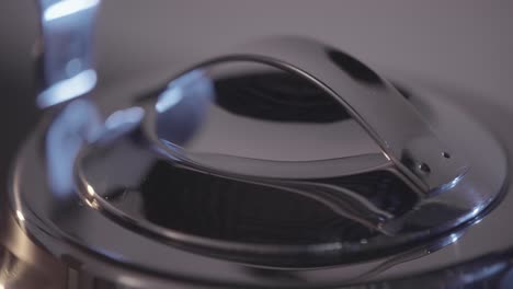 close-up of a stainless steel kettle lid and handle