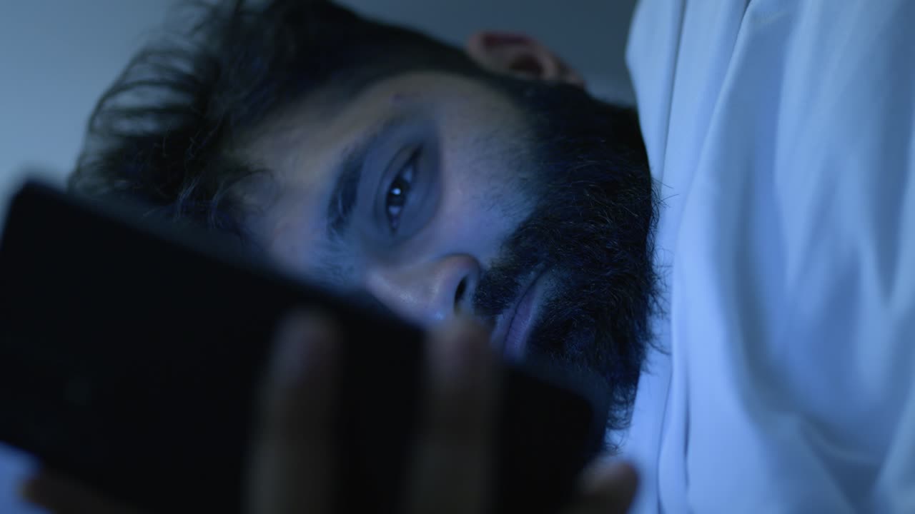 un tipo desplazándose por las redes sociales que sufre de insomnio a medianoche