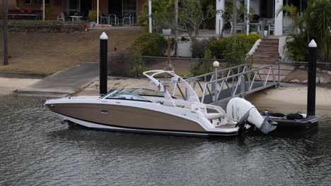 a motorboat approaches and docks at a pier.