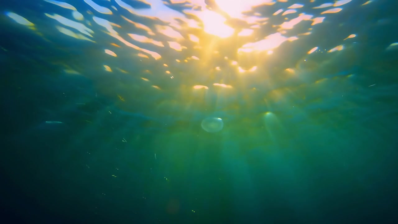 Onderwater zonnestralen die schijnen door helder blauw water