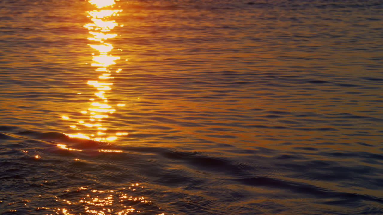 vista del agua del mar reflejando los rayos del sol en la costa. amanecer tranquilo en la playa.