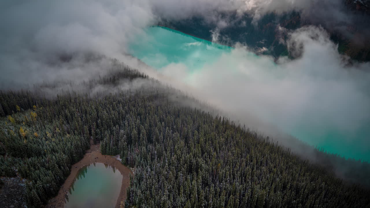 lapso de tiempo de formaciones de nubes sobre agua glacial azul agua y bosque siempre verde