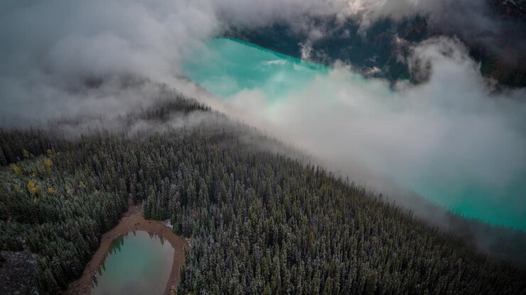 Timelapse di formazioni nuvolose sopra acqua glaciale azzurra e foresta sempreverde