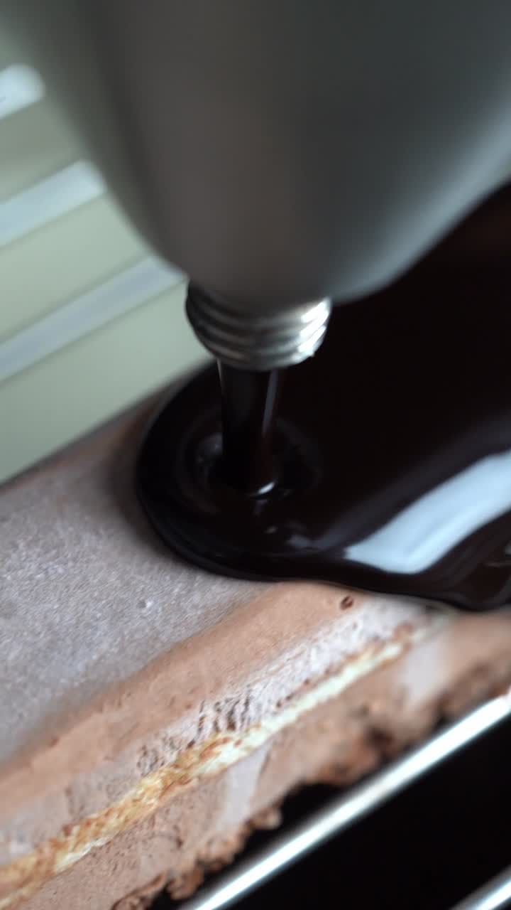 A chief put a chocolate sauce to a cake, close up shot, insert shot