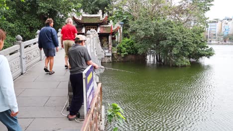 gente caminando hacia el templo sobre el puente del lago