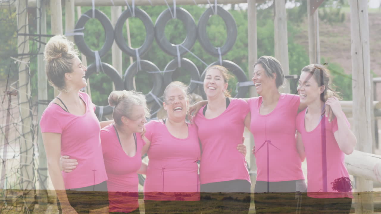 Laughing together at obstacle course, women in pink shirts enjoying animation