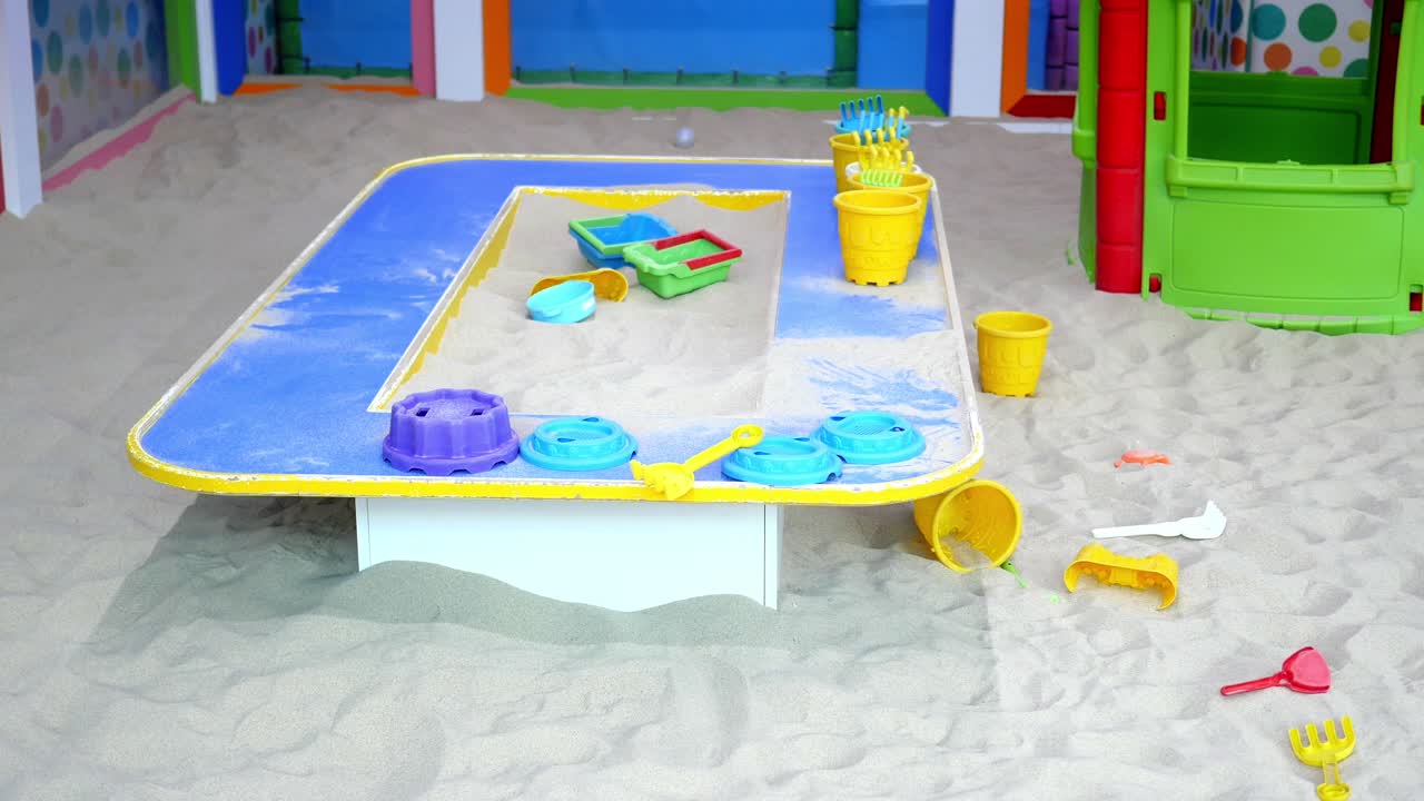 色とりどりの砂の遊び場で子供向けのおもちゃがあります