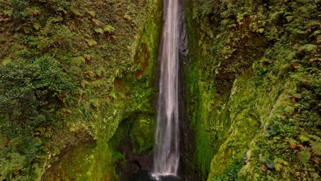 an breathtaking aerial view reveals the unique and beautiful vuelta al cañon waterfall, cascading majestically into a vibrant, untouched green canyon
