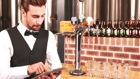 smiling barkeeper using tablet well dressed