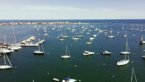 aerial footage of scituate harbor, low long pullback with drone, showing moored yachts, open ocean in distance