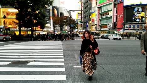 panning view revealing japanese businessman and pedestrian trying to get to opposite side before red light in shibuya, tokyo, japan.