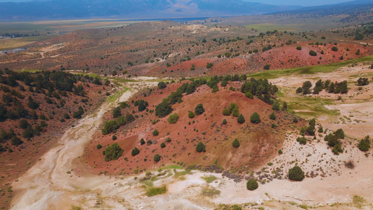 Unusual rocky landscape with soils of different colors. Daytime footage over the Travertine Hot Springs in California, USA.