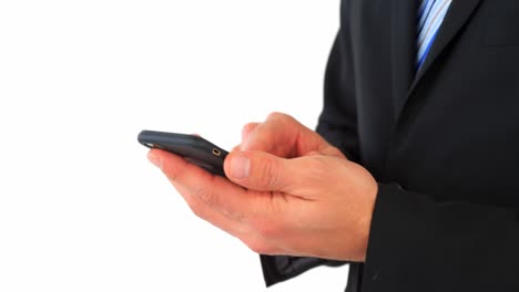 mid section of businessman text messaging on mobile phone