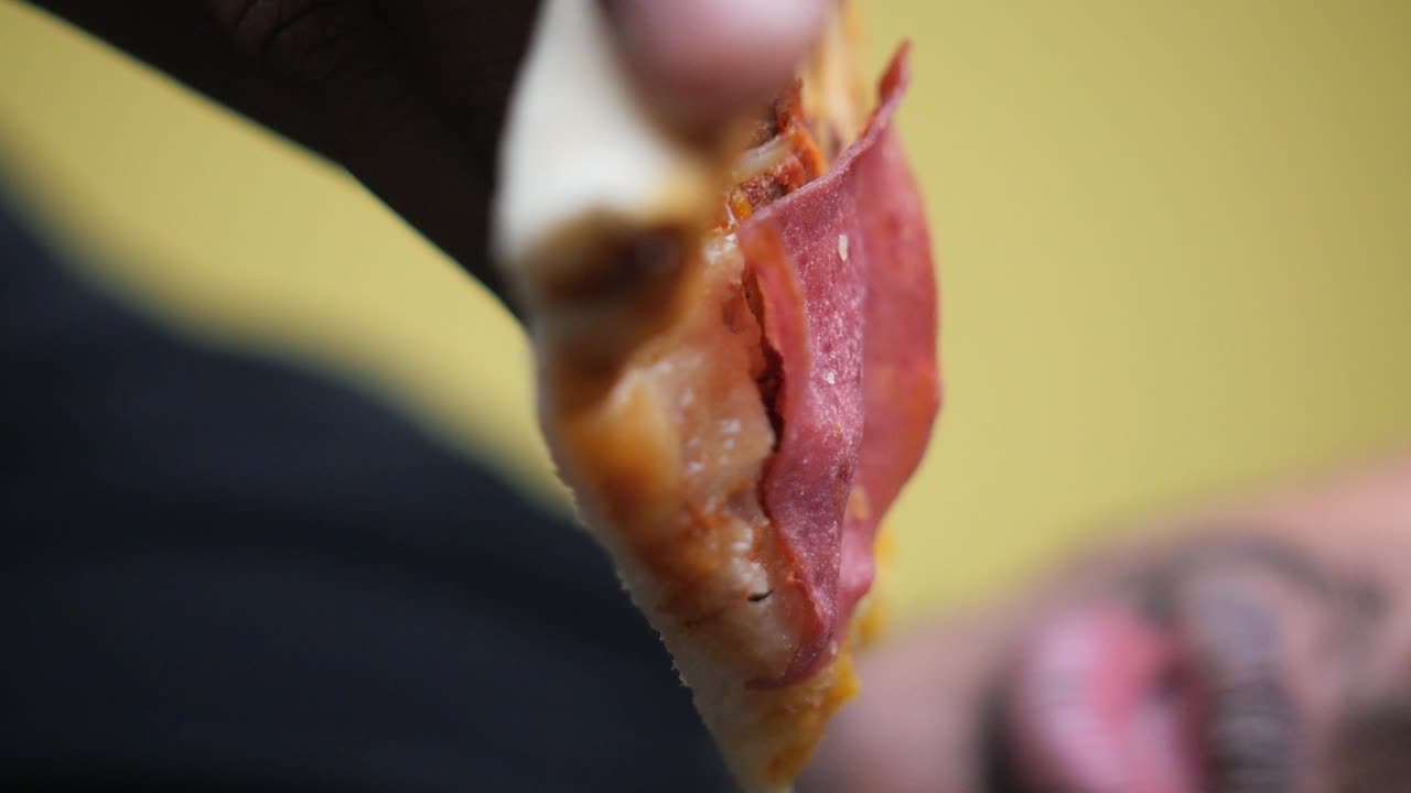 persona comiendo una rebanada de pizza