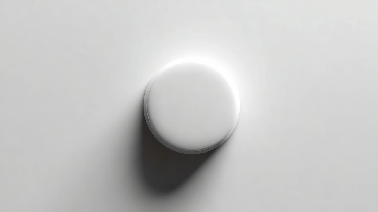 A sleek, minimalistic circular object gracefully positioned against a smooth, light-colored surface, showcasing its soft shadow and subtle glow, highlighting its modern design and elegance