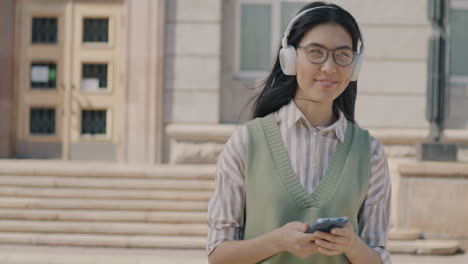 woman listening to music on campus
