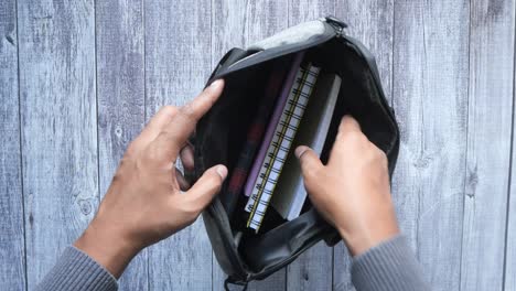 young man searching something in a shoulder bag