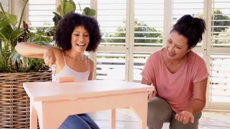 painting table, mother and adult daughter smiling and enjoying diy home improvement project