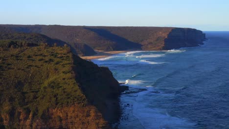 Vista-Aérea-De-Los-Acantilados-Costeros-Con-Olas-Del-Océano-Salpicando