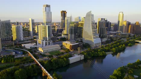 aerial view around a cargo train crossing a bridge in austin, texas, calm, summer sunset in usa - circling, drone shot