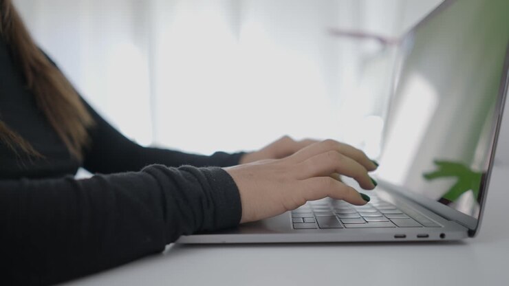 Frau tippt auf Laptop