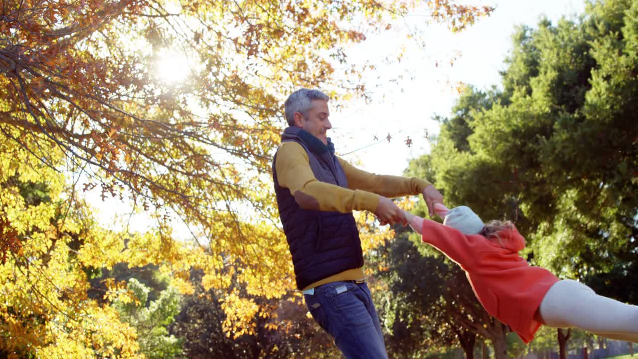 padre girando a su hija al aire libre