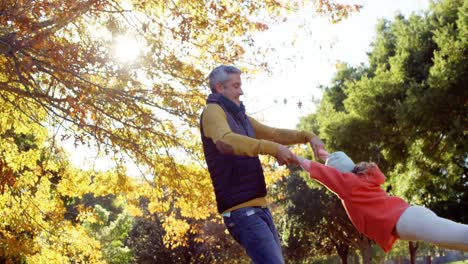 Dad-spinning-daughter-around-outdoors