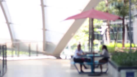 two people conversing at an outdoor table