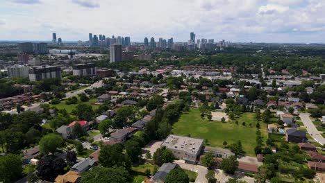 aerial view of houses and a park over a sunny mississauga