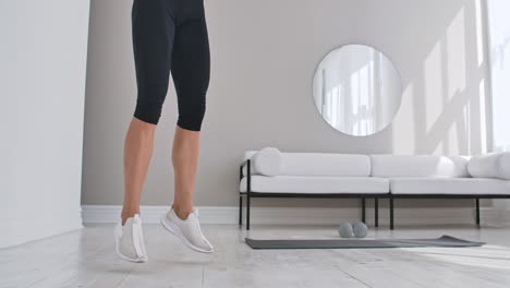 woman doing jumping jacks at home. sportswoman doing jumping jacks exercise at home